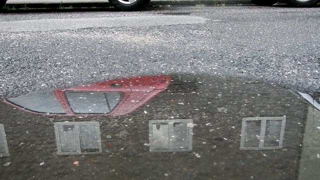 Auto f&auml;hrt durch Wasserpf&uuml;tze