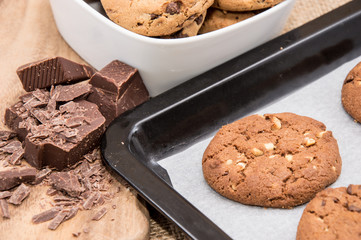 Fresh cookies on a griddle with chocolate pieces