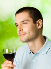 Thinking man with redwine, outdoors