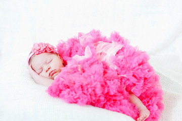 Fototapeta na wymiar sleeping small princess in pink laces (the newborn girl)