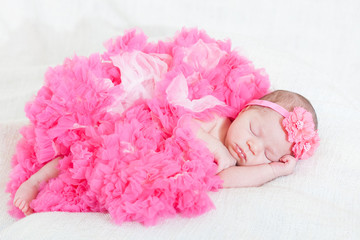 Obraz na płótnie Canvas sleeping small princess in pink laces (the newborn girl)