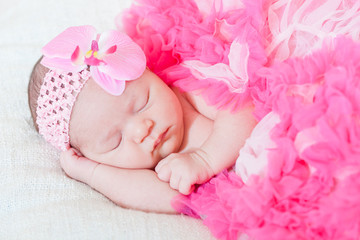 Obraz na płótnie Canvas sleeping small princess in pink laces (the newborn girl)