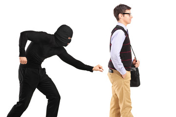 A pickpocket with mask trying to steal a wallet