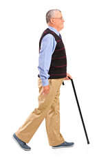 Full length portrait of a senior man walking with cane