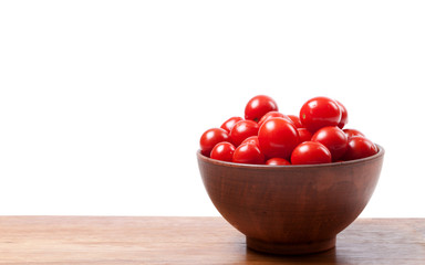 Cherry tomato in ceramic bowl on wooden kitchen table