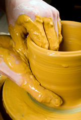 hands of a potter, creating an earthen jar on the circle