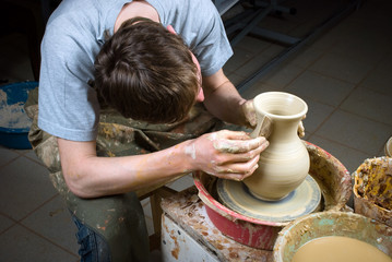 hands of a potter, creating an earthen jar on the circle