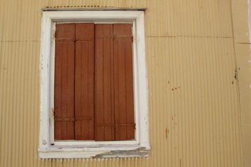 brown painted wood closed shutter door in a corrugated steel wall building