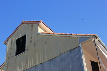 corrugated steel white painted wall barn with wooden louvre shutter windows.