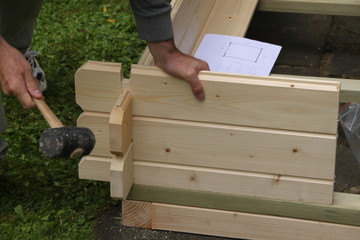 Mann beim Aufbau eines Gartenhauses