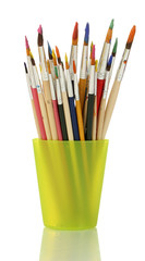 Paint brushes with gouache in cup isolated on white