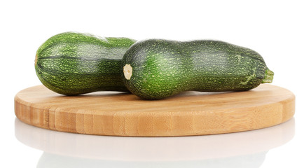 Fresh zucchini on chopping board isolated on white