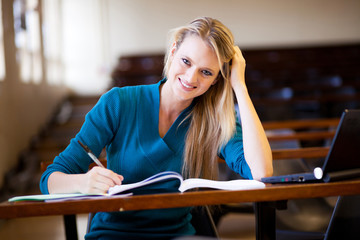 happy female college student sitting in classroom