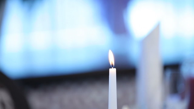 Candle burning on a beutifuly setted holiday table.
