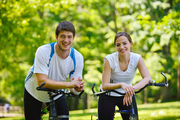 Happy couple riding bicycle outdoors