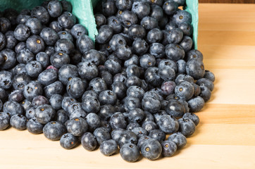 Blueberries spilling onto wooden table
