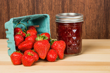 Strawberries in container with jam or jelly