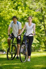 Happy couple riding bicycle outdoors