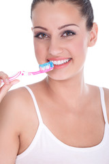 Beautiful young woman brushing her teeth