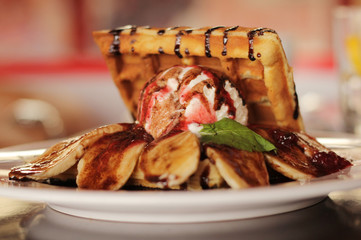 Waffles with strawberry syrup on white ceramic plate