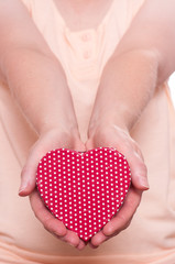 Zwei Hände halten ein rotes Herz nach vorne