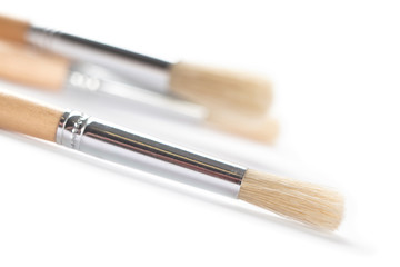 Fototapeta premium Three bright brushes are lying on white background, isolated