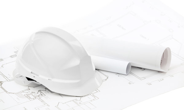 White hard hat near working drawings on white background
