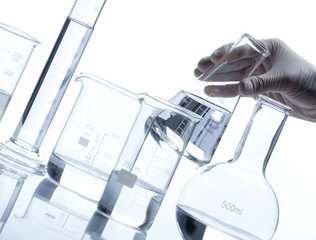Group of empty glass flasks with a hand holds one of them