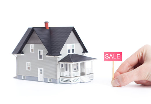 Household architectural model with sale sign, isolated