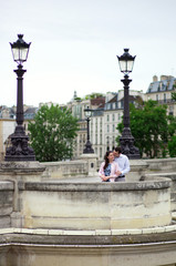 Fototapeta premium Dating couple is kissing gently in Paris on a bridge