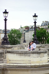 Dating couple is kissing gently in Paris on a bridge