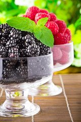 Sweet fresh fruits in glass goblet with mint leaf