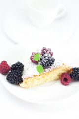 cup, cake, raspberry, blackberry and mint on a plate on a white