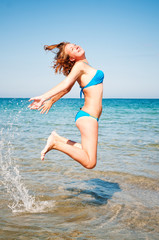 Naklejka premium young girl jumping out of a water