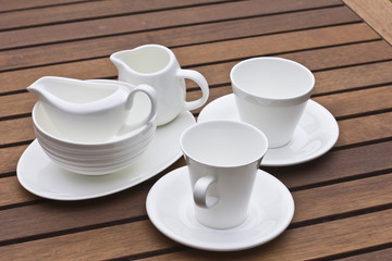 A lot of white crockery on wooden background