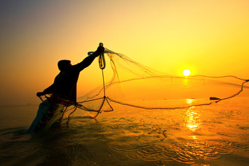 throwing fishing net during sunrise