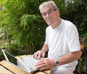retraité actif et moderne, utilisant un ordinateur portable