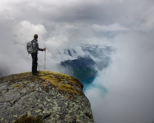 Man with hiking equipment standing on rock's edge