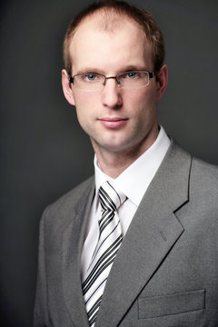 Portrait of businessman wearing a grey suit and black white tie