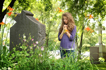 Girl praying at the cemetery