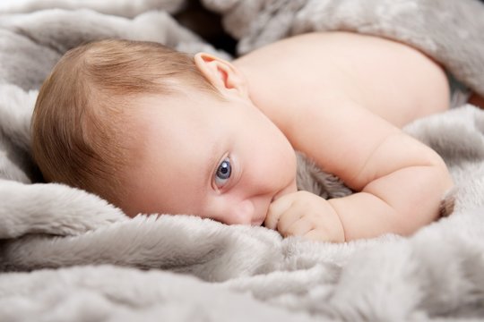 Baby kuschelt mit Decke