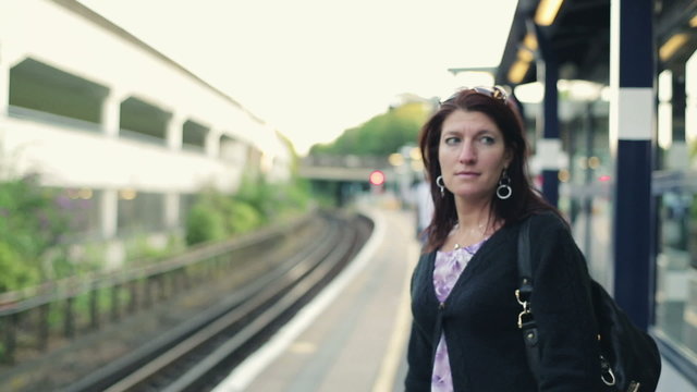 Woman waiting for a train on station, steadicam shot