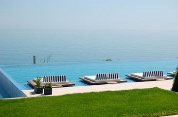 Infinity swimming pool by beach at the modern luxury hotel, Pier