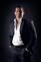 Fototapeta premium Cool businessman posing against a black background