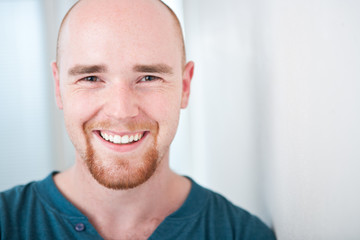 Closeup portrait of happy young man smiling isolated on white ba