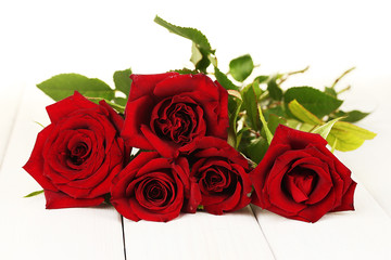 bouquet of red roses on a white wooden table close-up