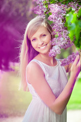 Obraz na płótnie Canvas Smiling beautiful woman with violet flowers