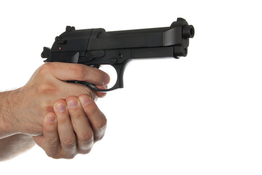 Two hands holding a gun with finger on the trigger