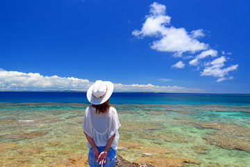久高島の岬で寛ぐ女性 © sunabesyou
