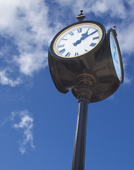 Old street clock over blue sky background
